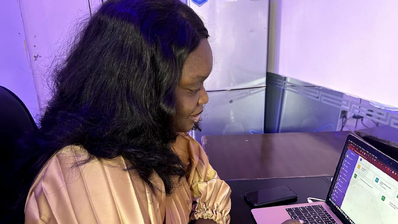 A woman sitting in front of a laptop computer accessing her purplepay dashboard
